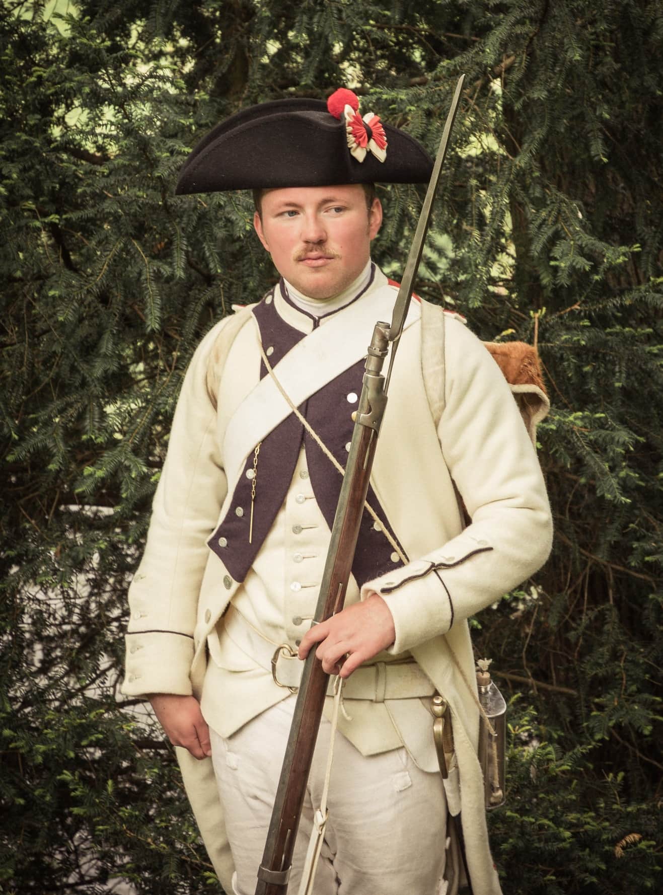 A solider or saldat of the Compagnie de Grenadiers of Le Gatinois, played by 18th century reenactors of Redcoats and Revolutionaries